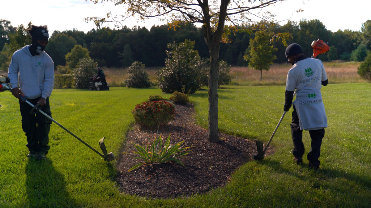 Green Acres crew edging and mulching planting beds
