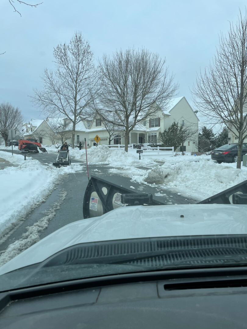 Plow truck clearing snow from a commercial parking lot