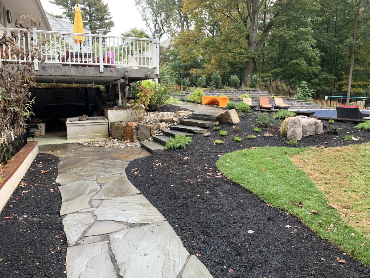 Landscape construction crew installing plantings and stonework