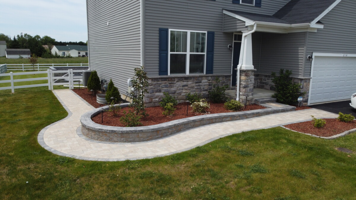 Paver walkway and raised planting beds at the front of a home