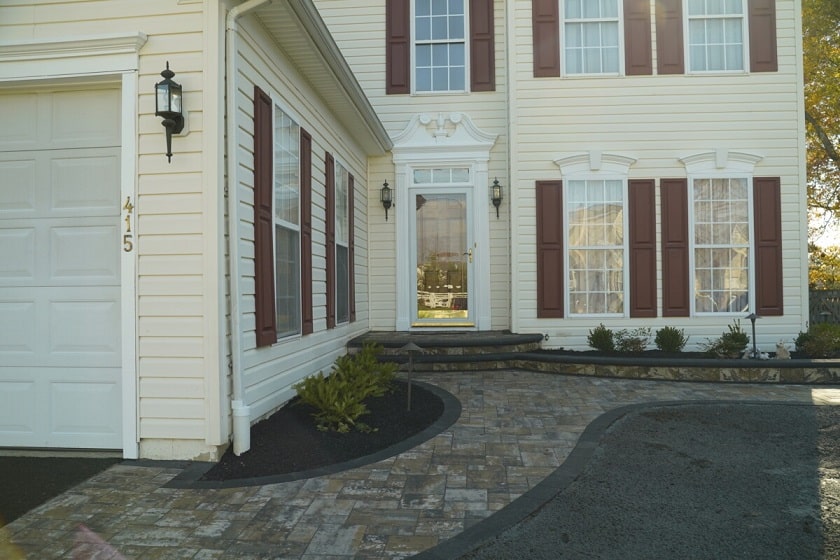 Paver walkway winding through a planted Delaware landscape